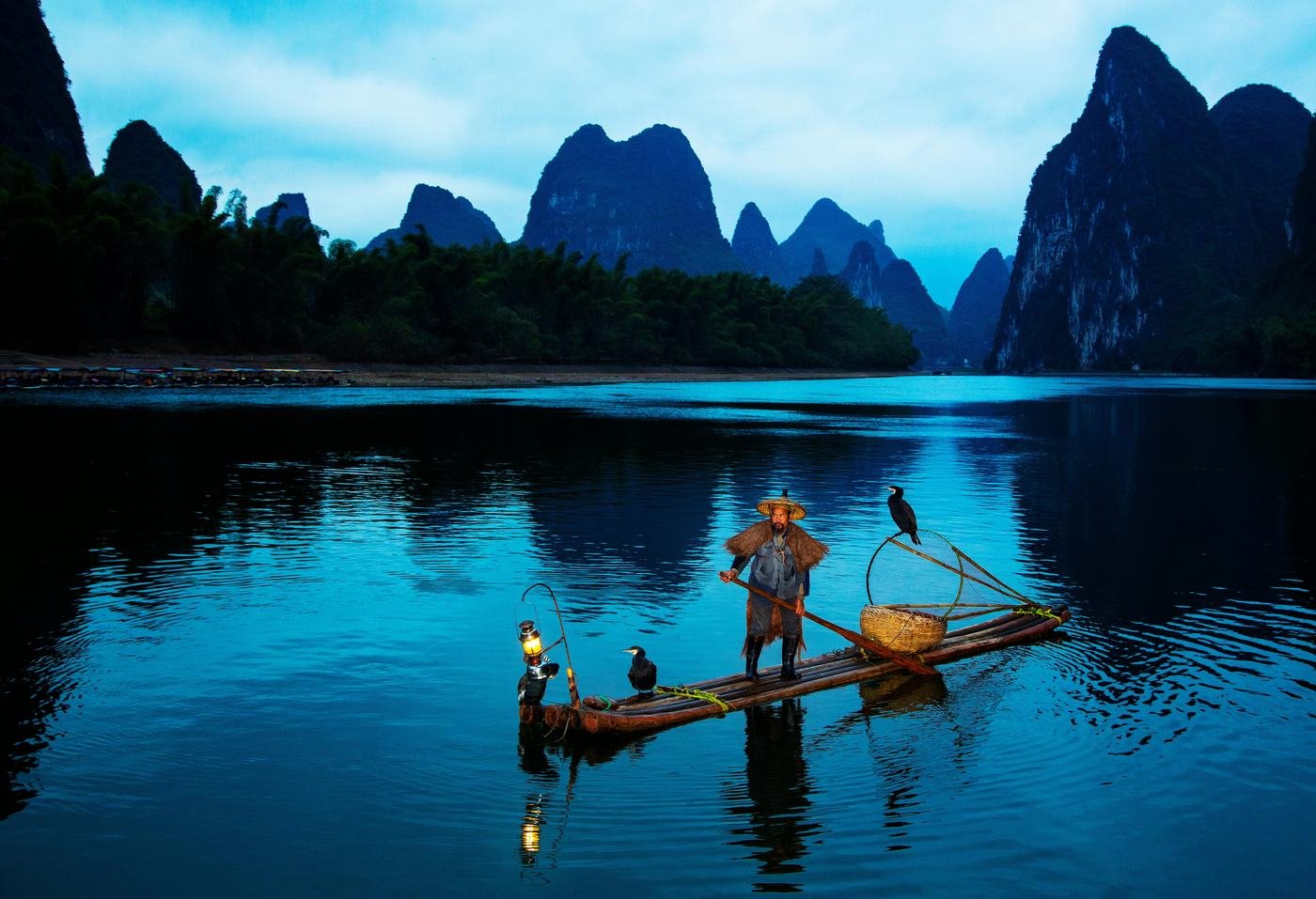 Pescador em barco de bambu no rio Li, Guilin